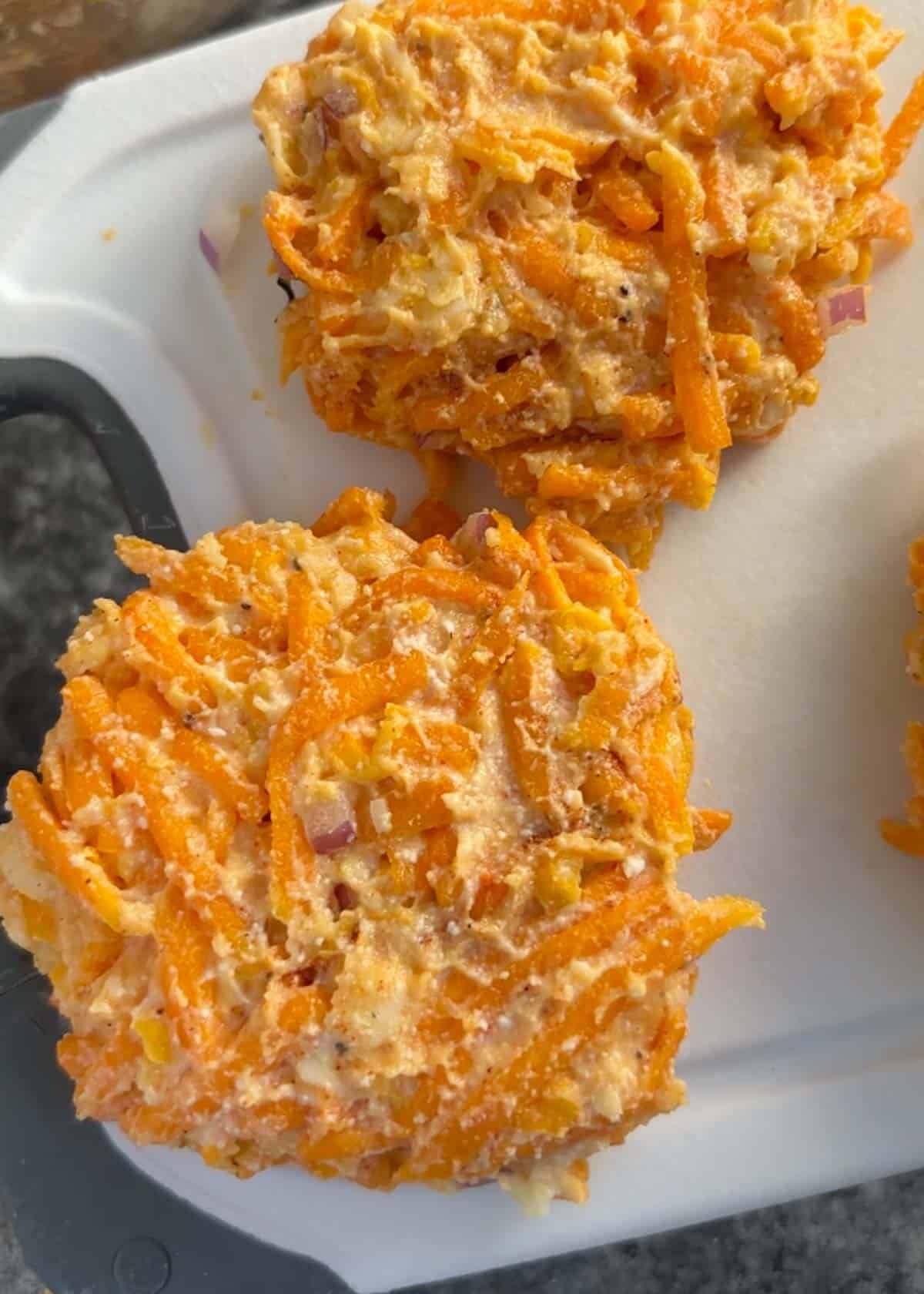 butternut squash fritters patted out on a cutting board