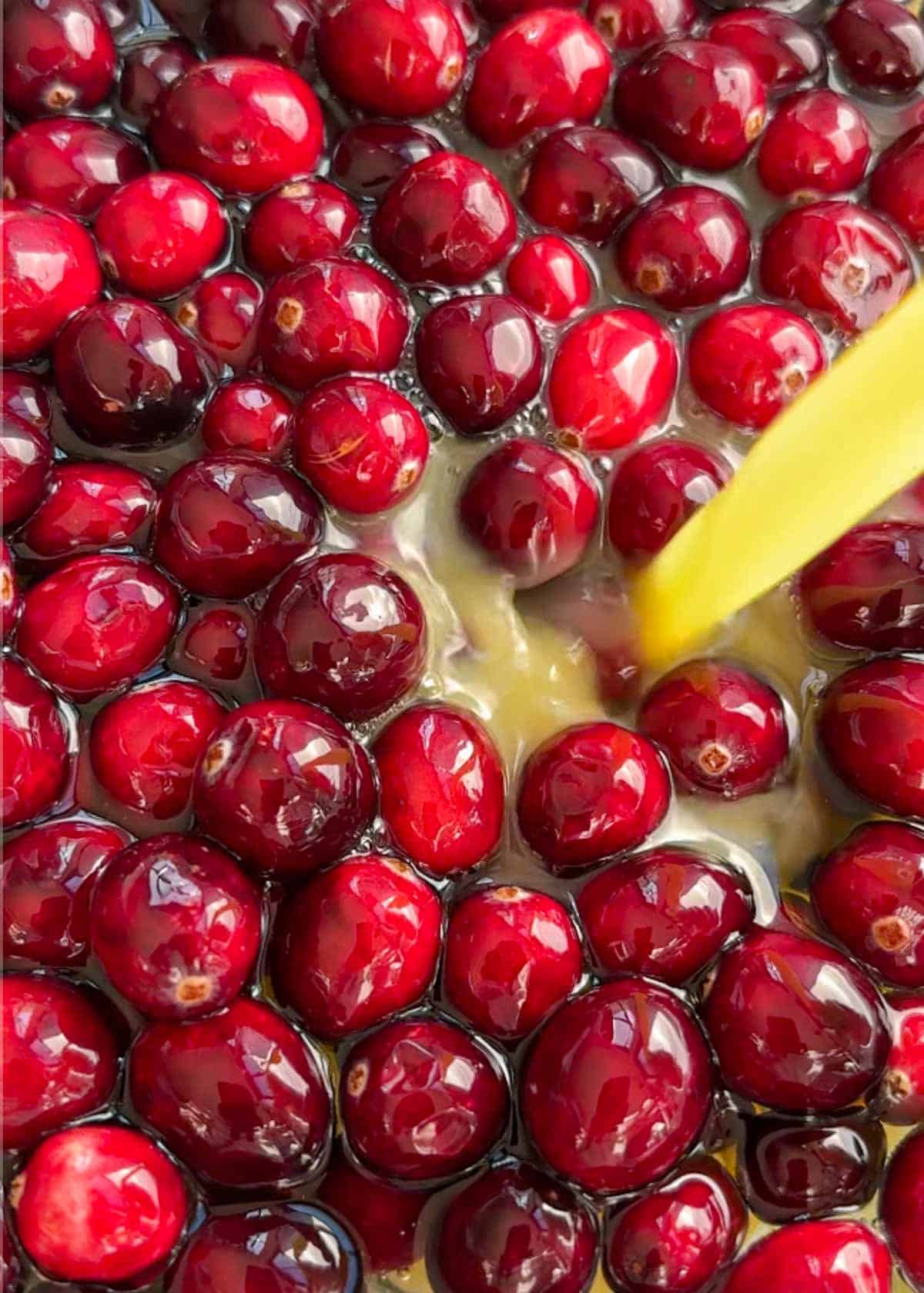 orange juice being poured over cranberries