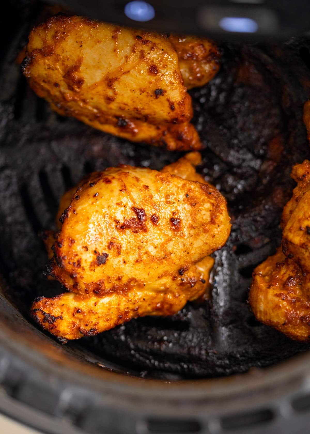 boneless, skinless chicken thighs in an air fryer basket