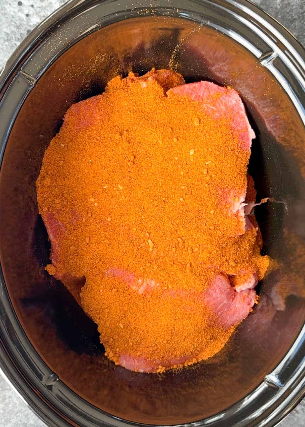 beef chuck roast covered in taco seasoning in a crock pot
