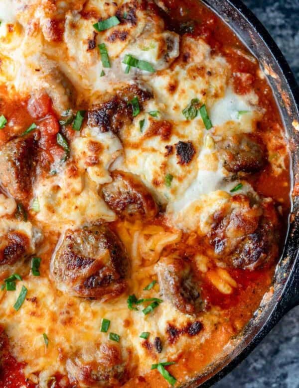overhead shot showing melty cheese on a meatball bake in a skillet