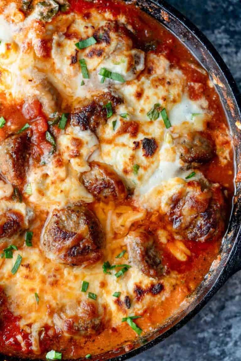 overhead shot showing melty cheese on a meatball bake in a skillet
