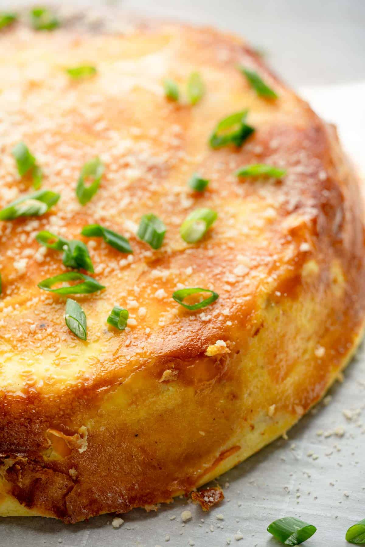 a close up of an unsliced spanish sweet potato omelette