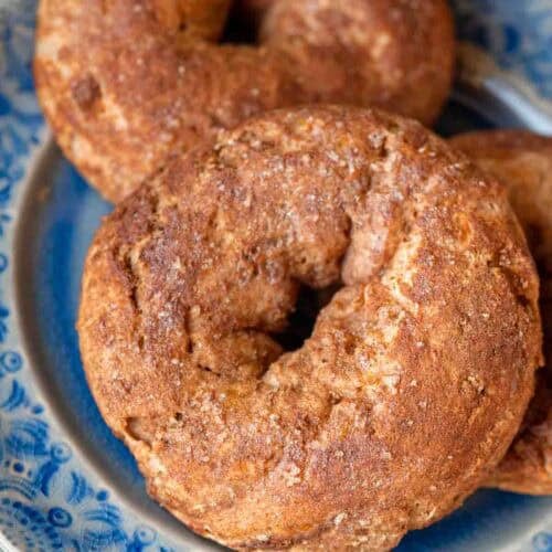 close up, overhead image of cinnamon protein bagels on a blue plate