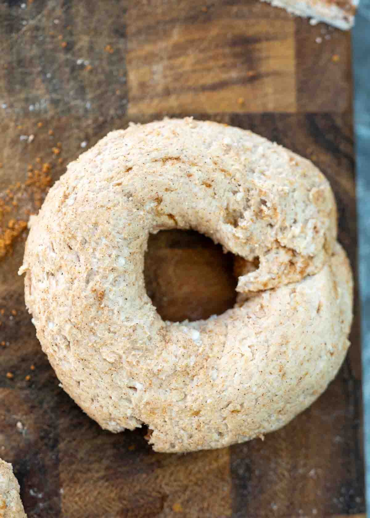 bagel dough rounded out in bagel form on wooden board
