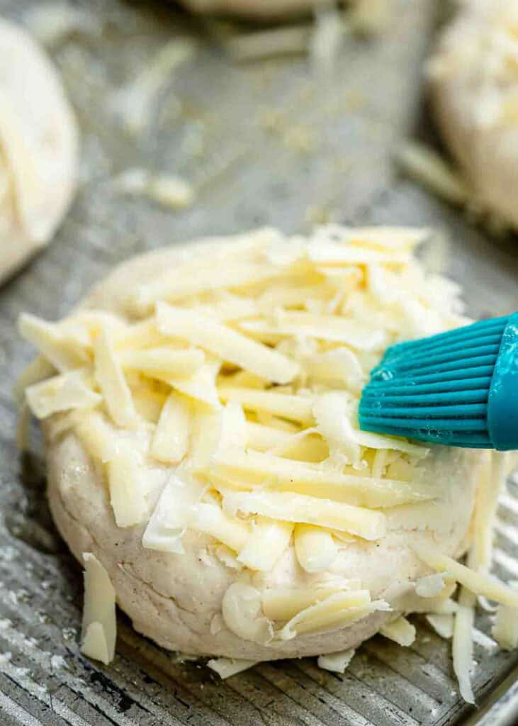 high protein cottage cheese bagels being brushed with an egg white