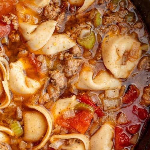 closeup shot of sausage tortellini soup in a pot with tomatoes and vegetables