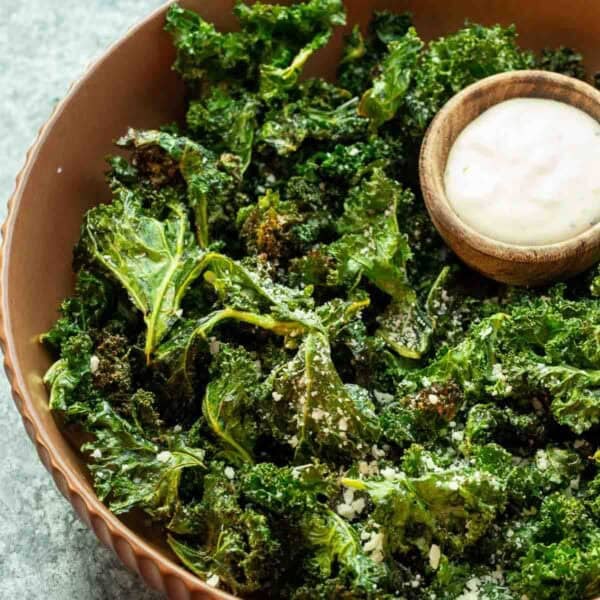 overhead image of kale chips and dip in a brown bowl