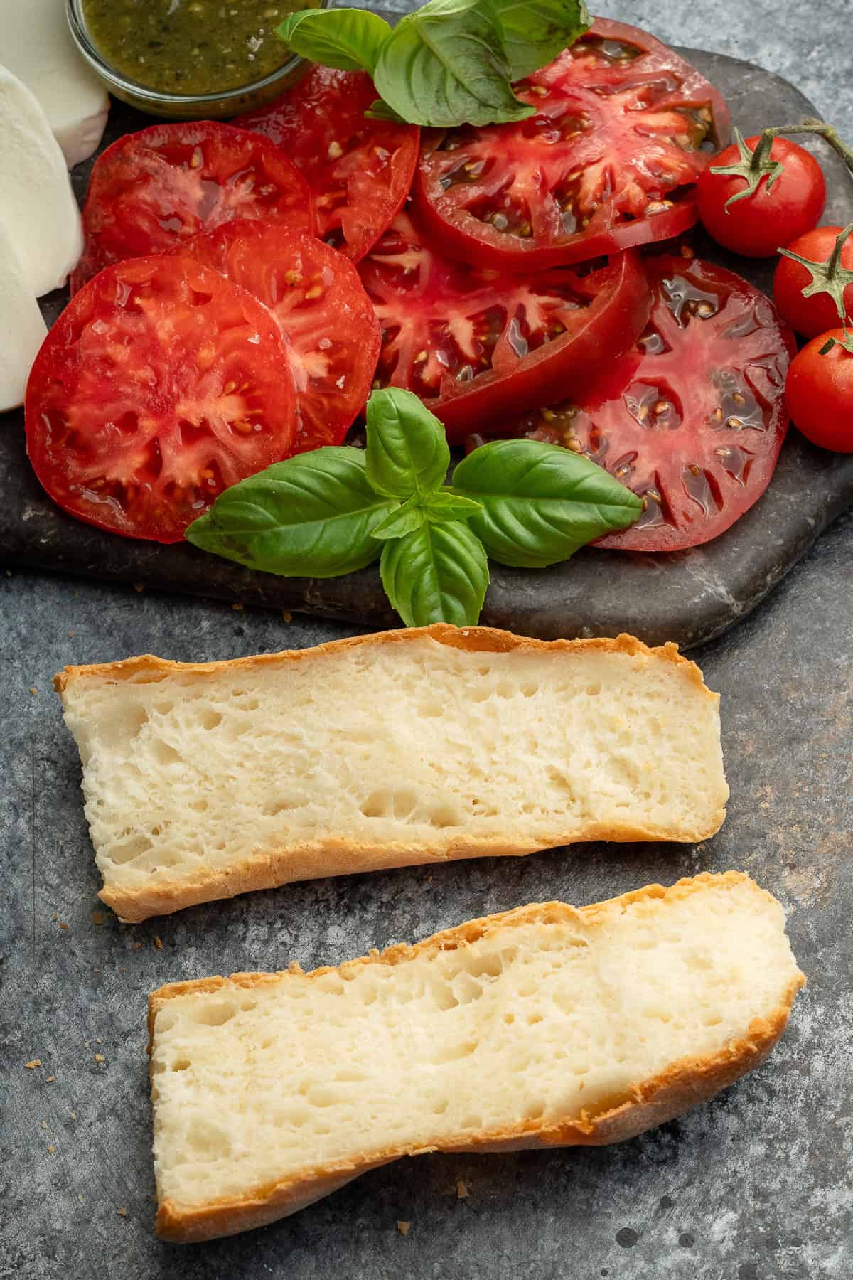 caprese sandwich ingredients on a stone cutting board