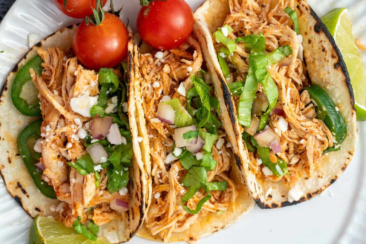 three tacos filled with tinga chicken