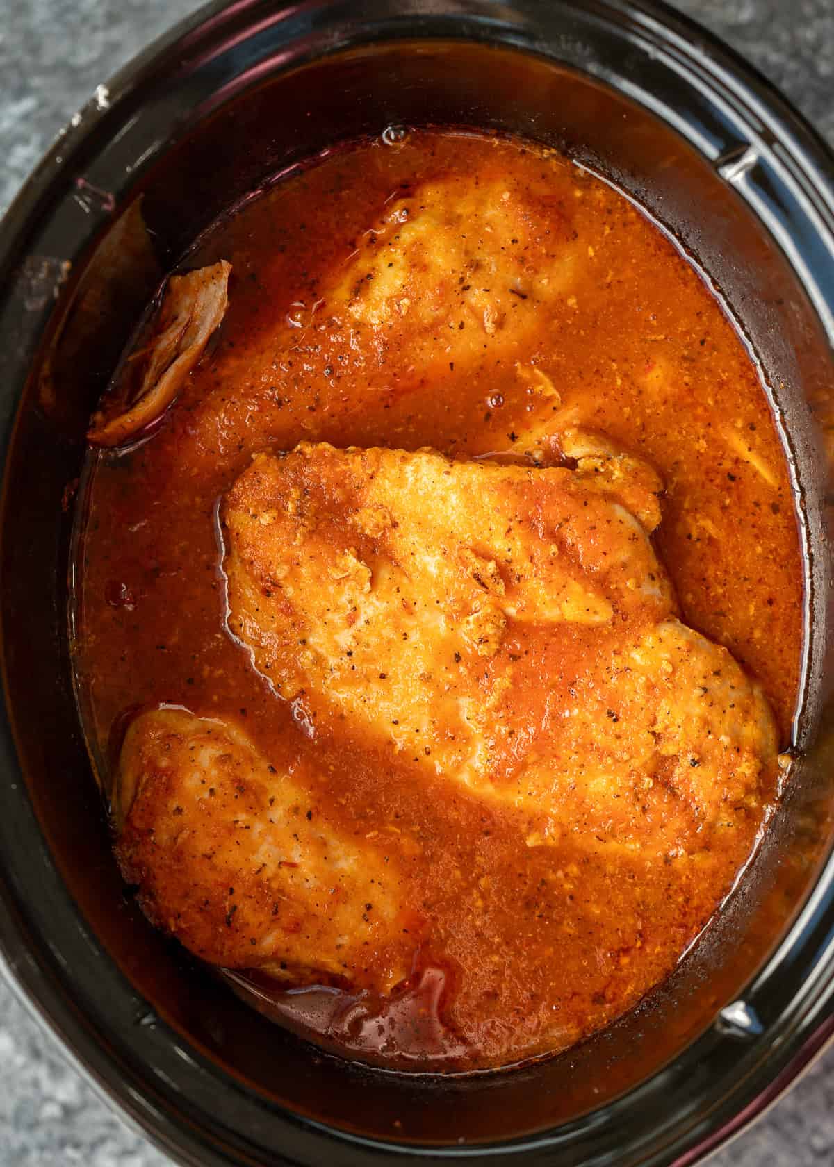 cooked chicken breasts in tinga sauce in slow cooker