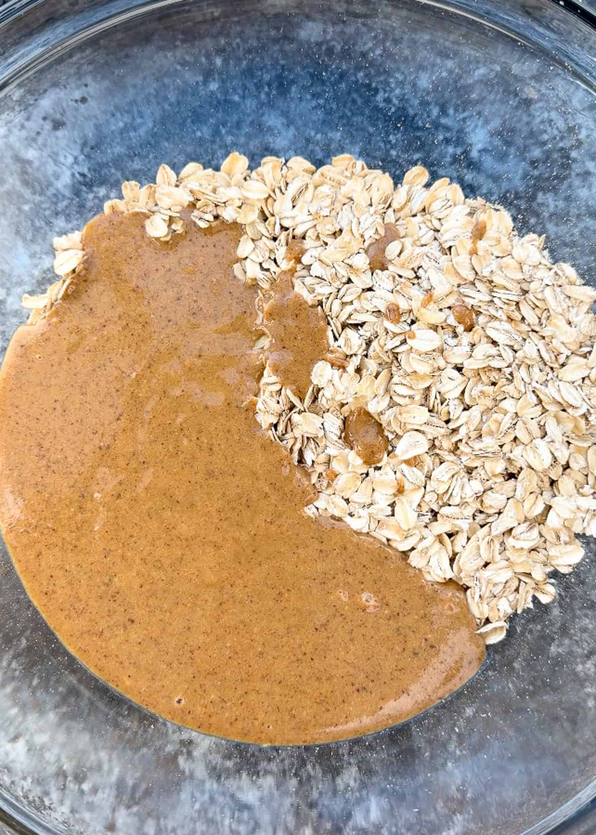 gluten free oats being added to mixing bowl with almond butter