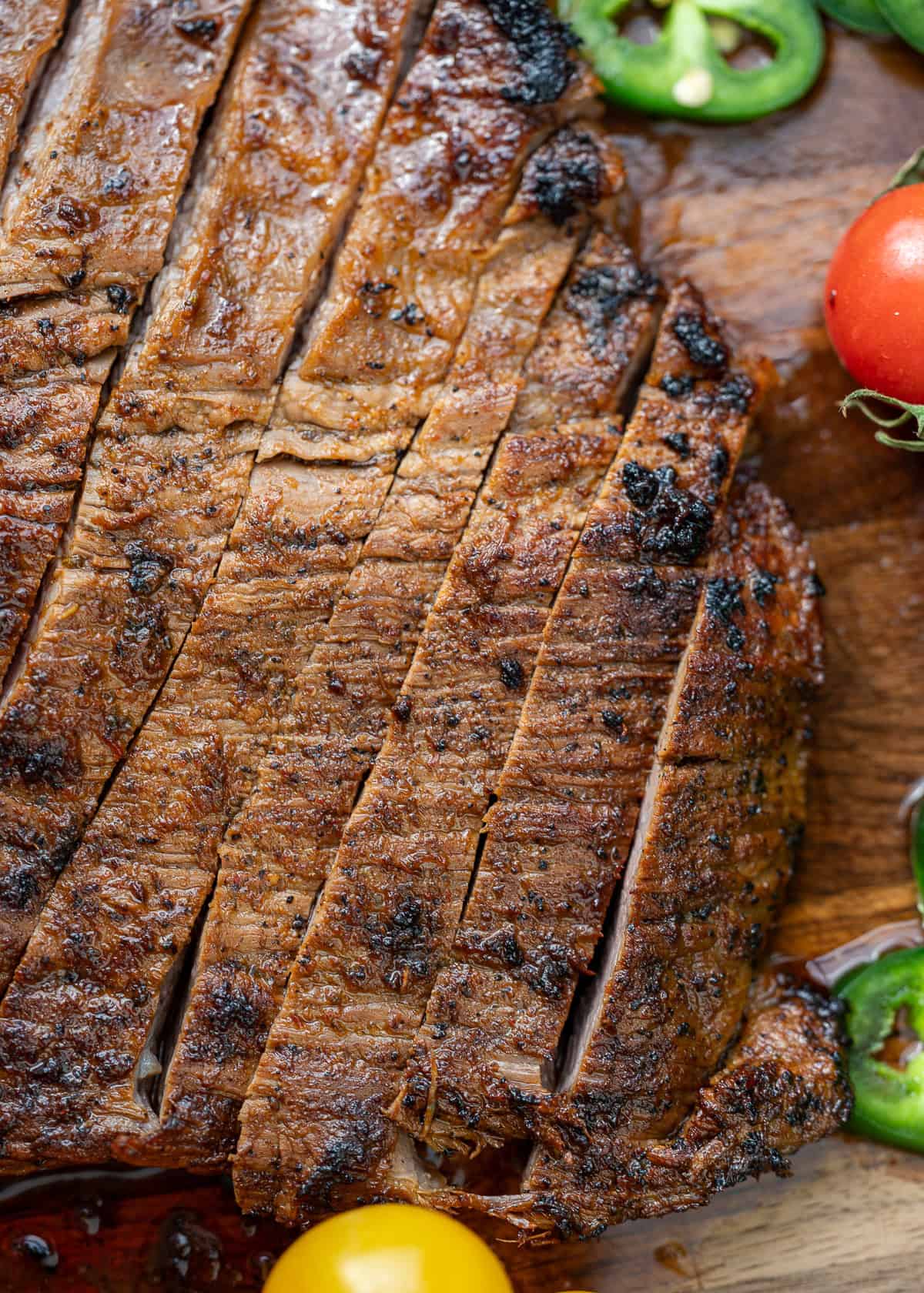 sliced carne asada on wooden cutting board