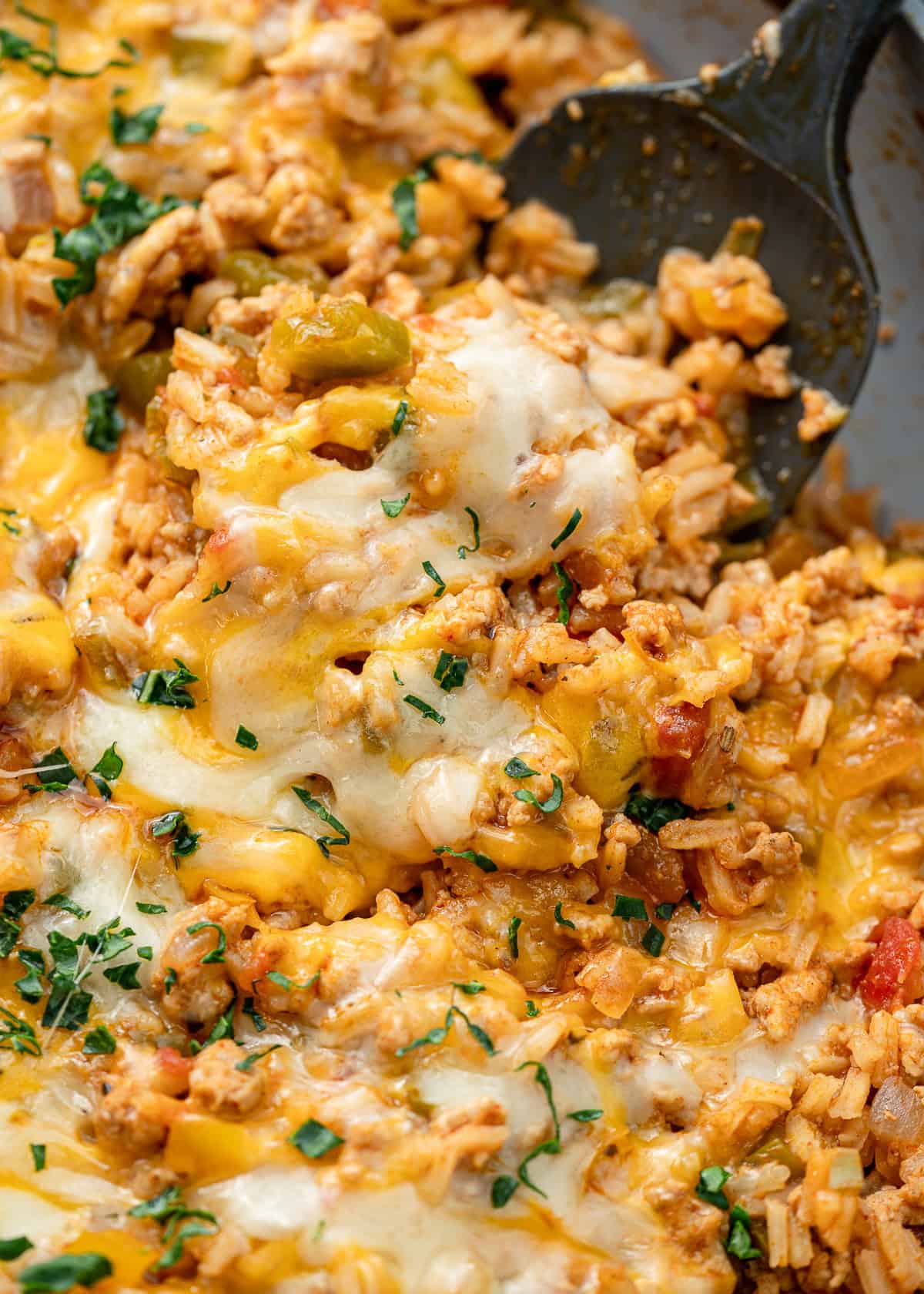 a spoon scooping a serving of deconstructed stuffed pepper skillet