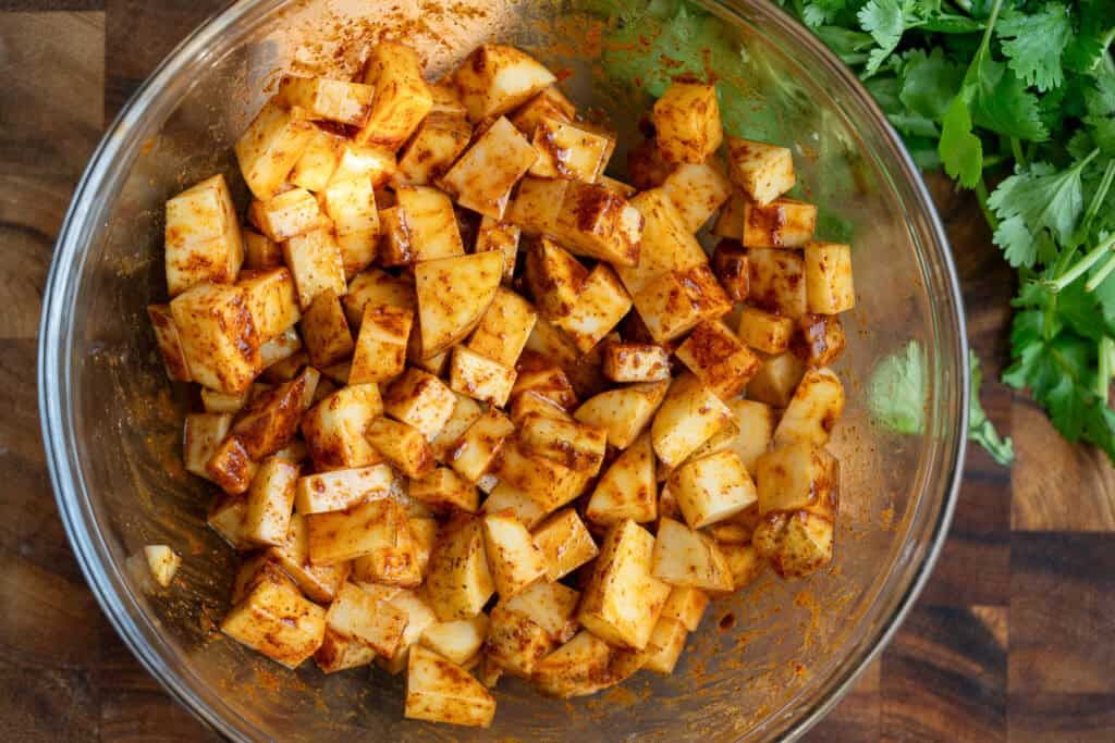 uncooked seasoned potatoes in a bowl