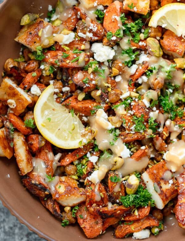 an overhead shot of hot honey halloumi salad with carrots, chickpeas and lemon in a brown bowl