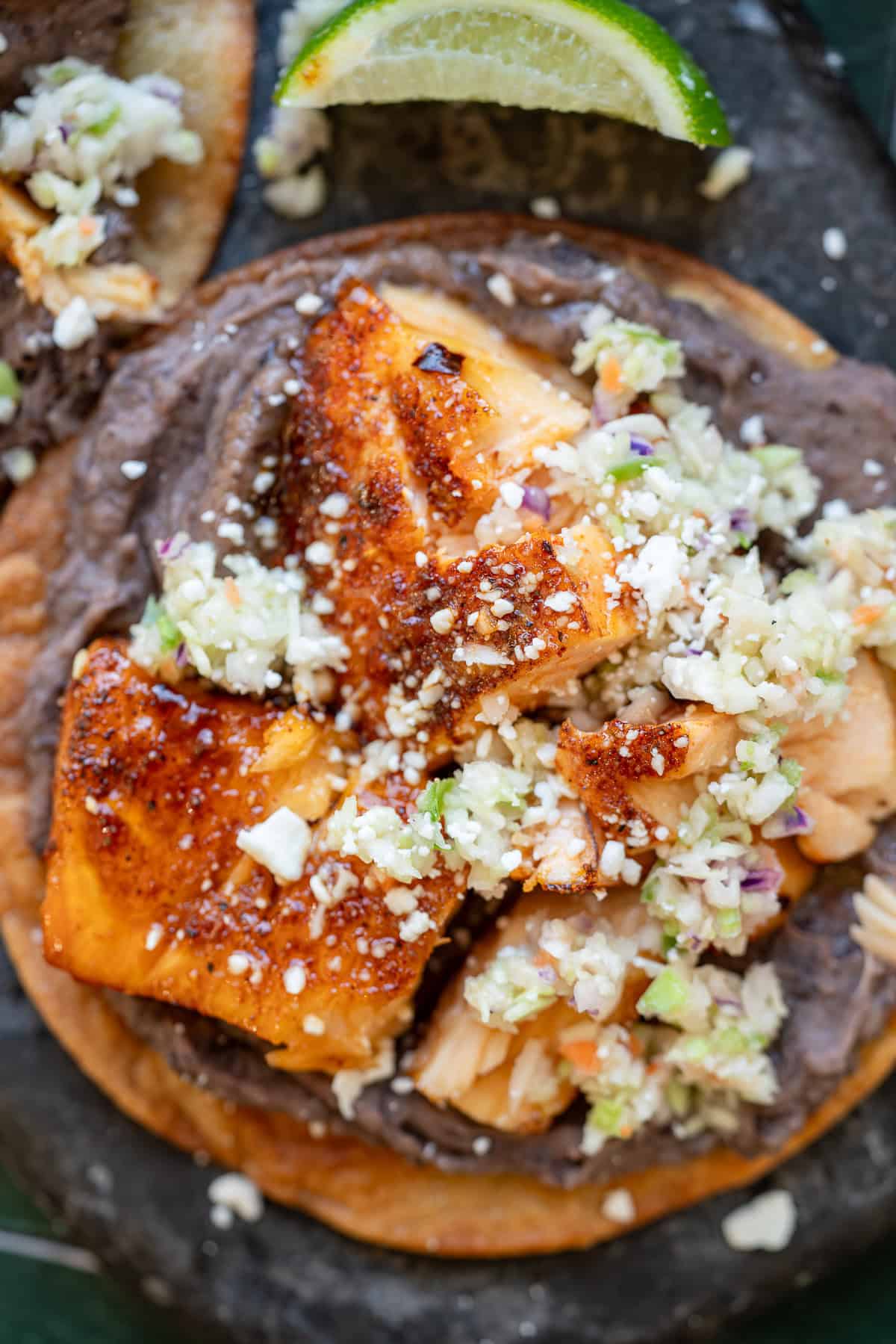 a closeup shot of hot honey salmon on a tostada
