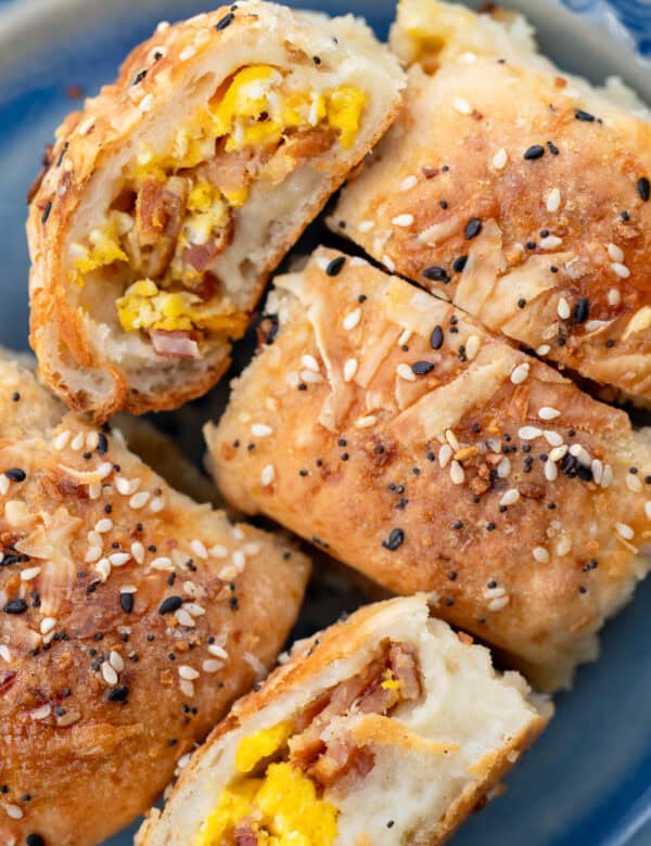 several high protein breakfast rolls on a plate, all stuffed with bacon, egg, and cheese