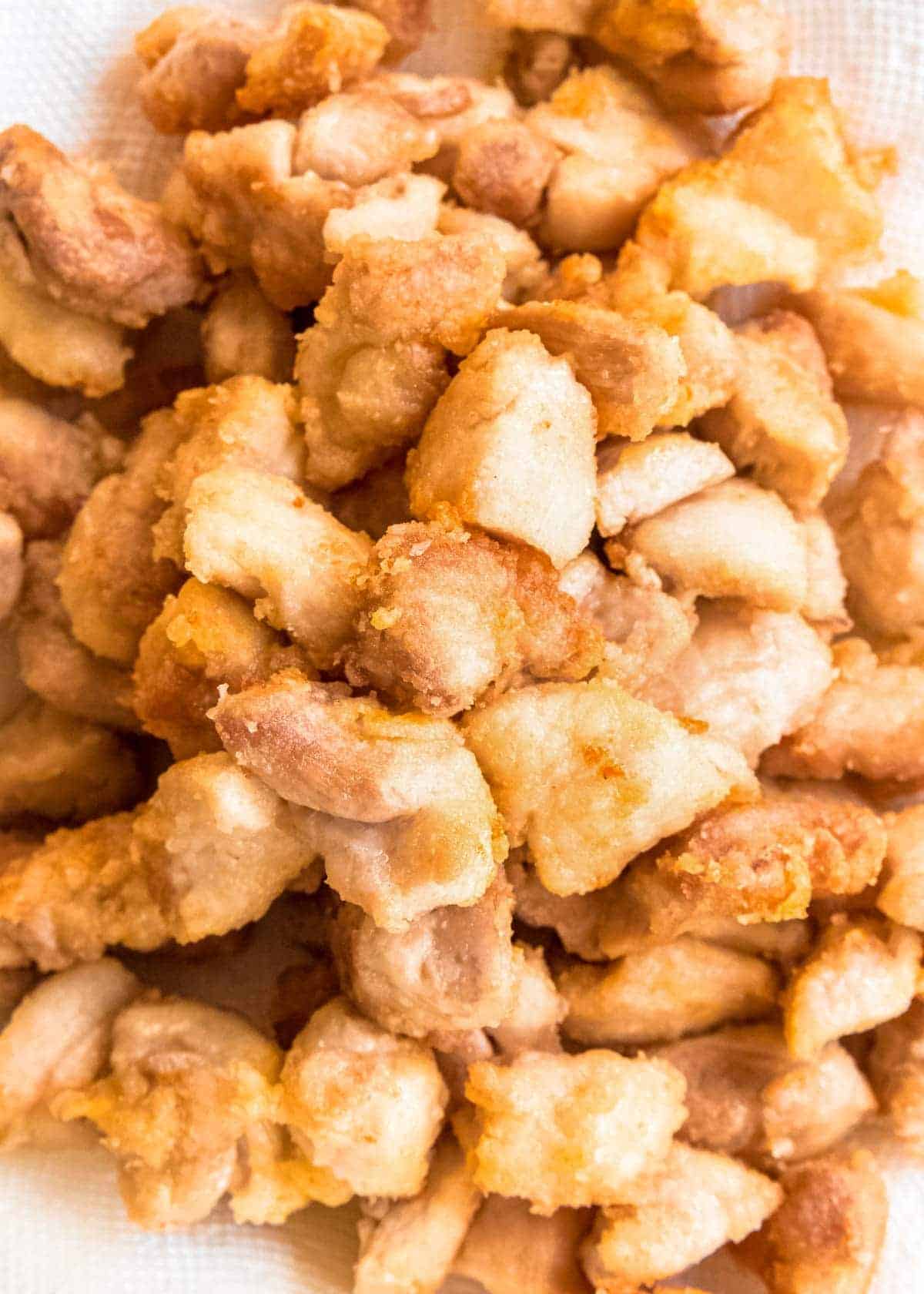 lightly breaded and fried chicken pieces on a plate lined with paper towels