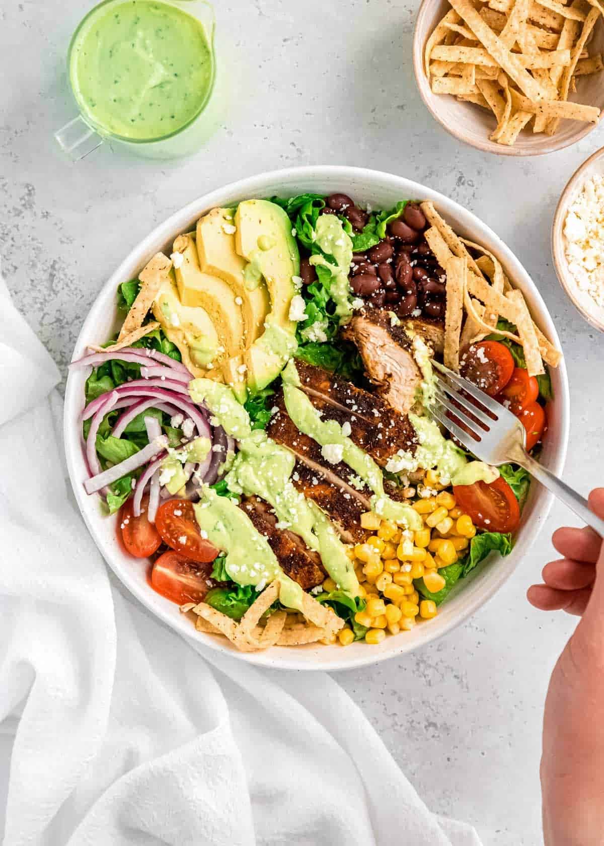 overhead image of garnished southwest chicken salad and a fork in a white bowl