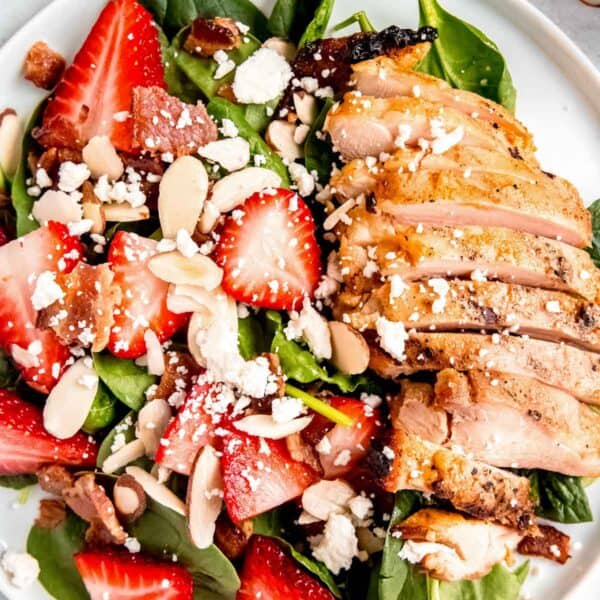 overhead image of strawberry spinach salad on a white plate