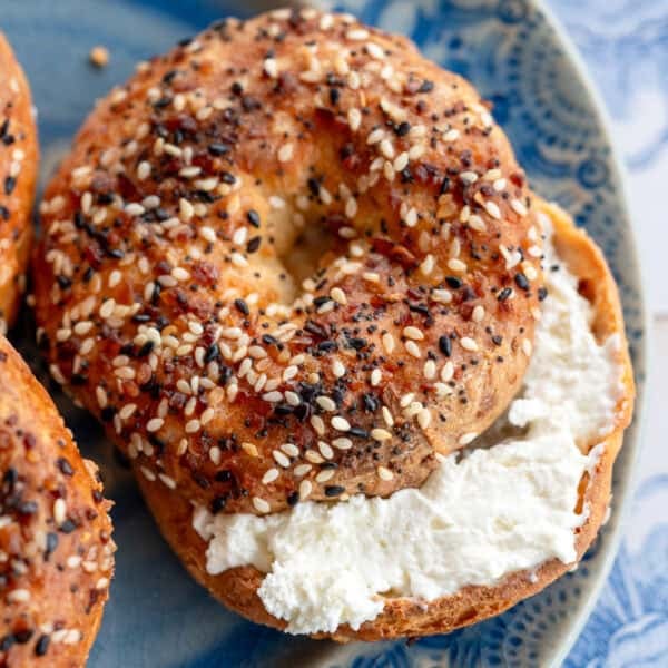 an overhead shot of a toasted everything bagel on a blue plate