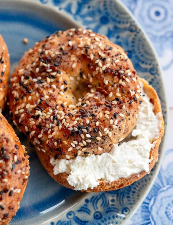 an overhead shot of a toasted everything bagel on a blue plate