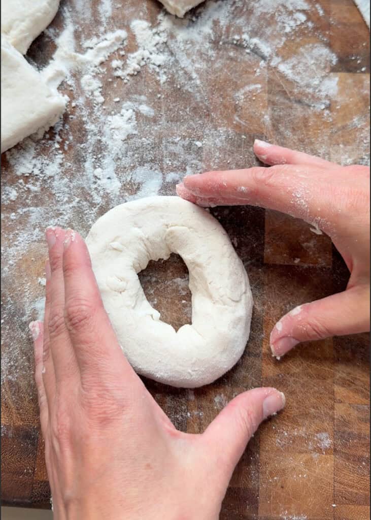 dough being formed into bagels