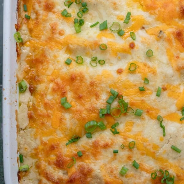 overhead image of cooked high protein chicken enchiladas in a white baking dish