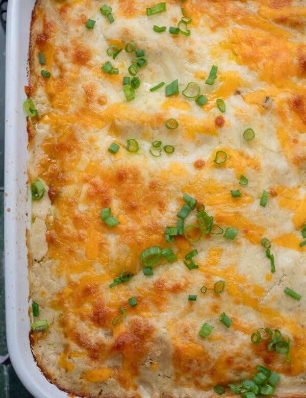 overhead image of cooked high protein chicken enchiladas in a white baking dish