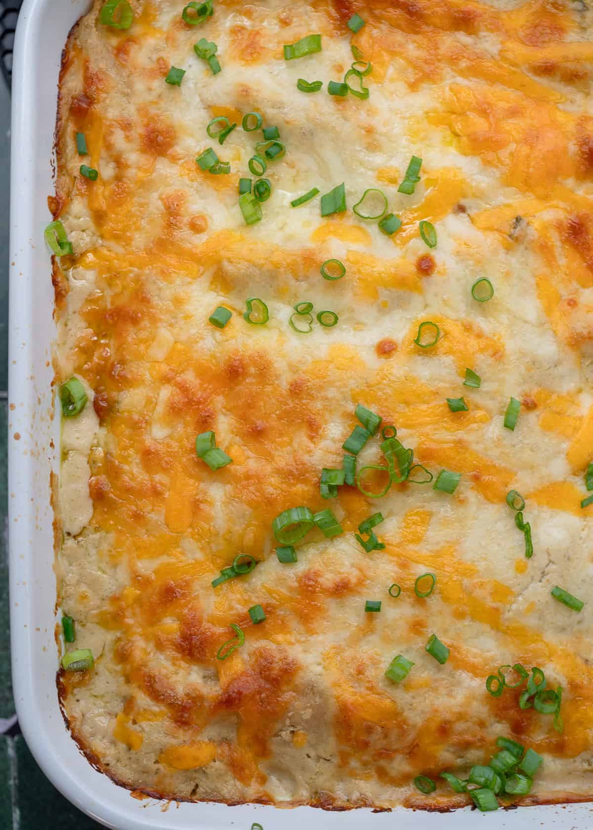 overhead image of cooked high protein chicken enchiladas in a white baking dish