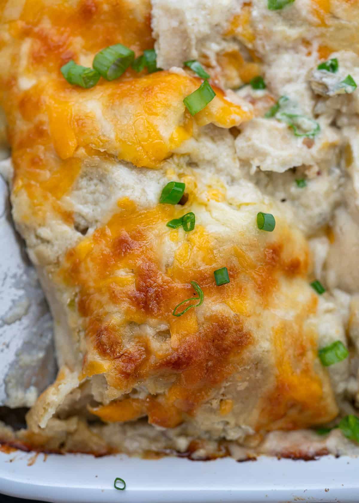 close up, overhead image of high protein chicken enchiladas in a white baking dish