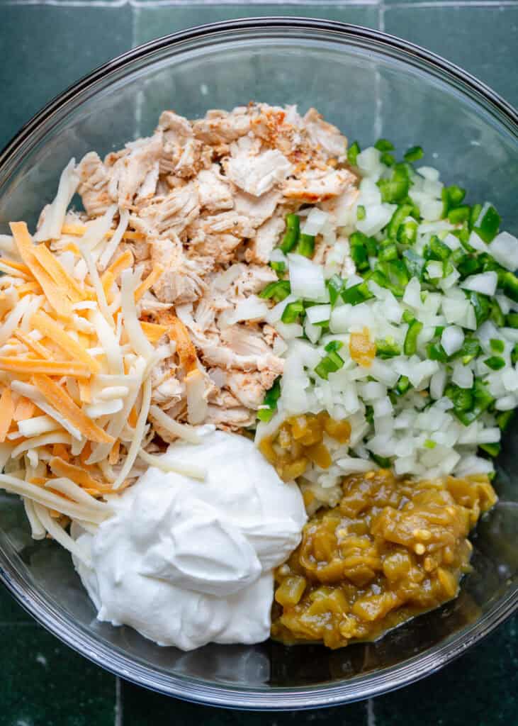 high protein chicken enchilada ingredients in a clear mixing bowl