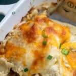 close up, overhead image of high protein chicken enchiladas being scooped from a white dish