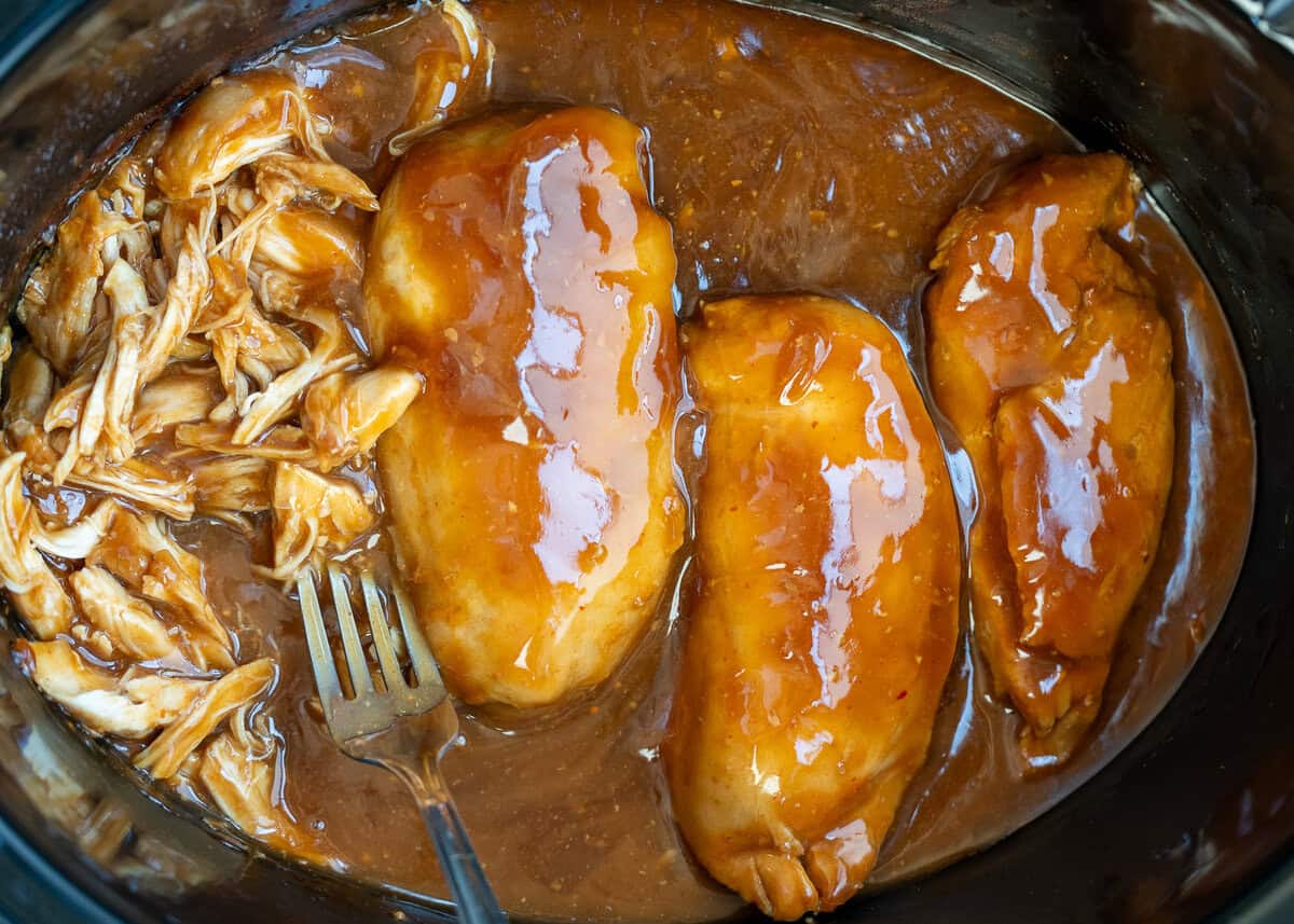 overhead shot of sweet chili chicken cooked in a black crock pot