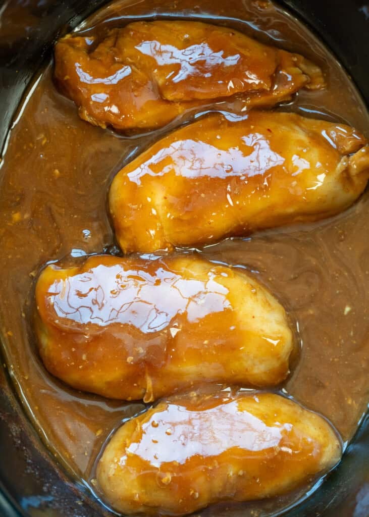 an overhead shot of cooked sweet chili chicken in a crock pot