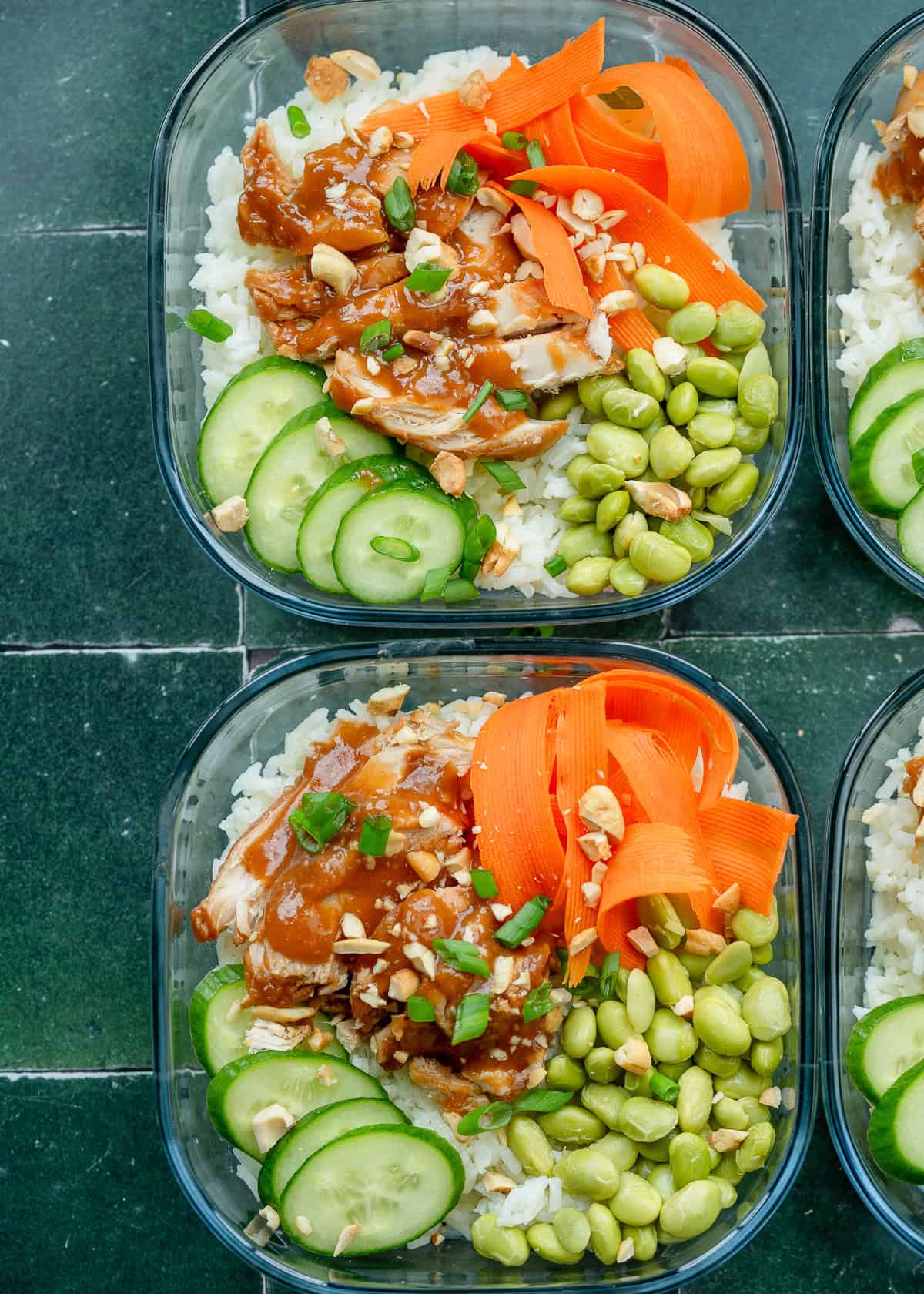 an overhead shot of meal prep lunch bowls featuring rice, chicken, and vegetables.