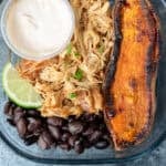 close up image of one honey chipotle chicken bowl in a clear meal prep container