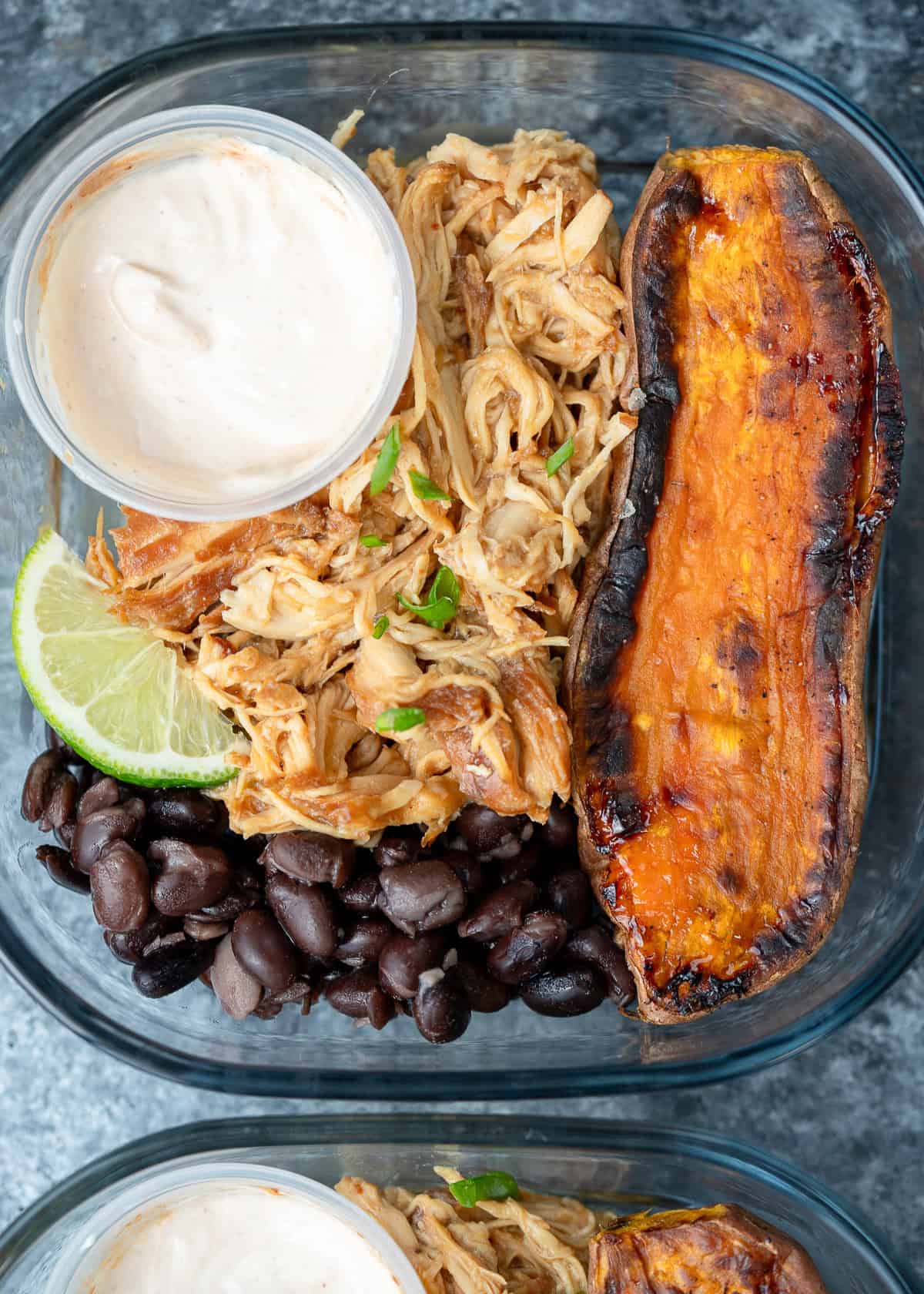 close up image of one honey chipotle chicken bowl in a clear meal prep container