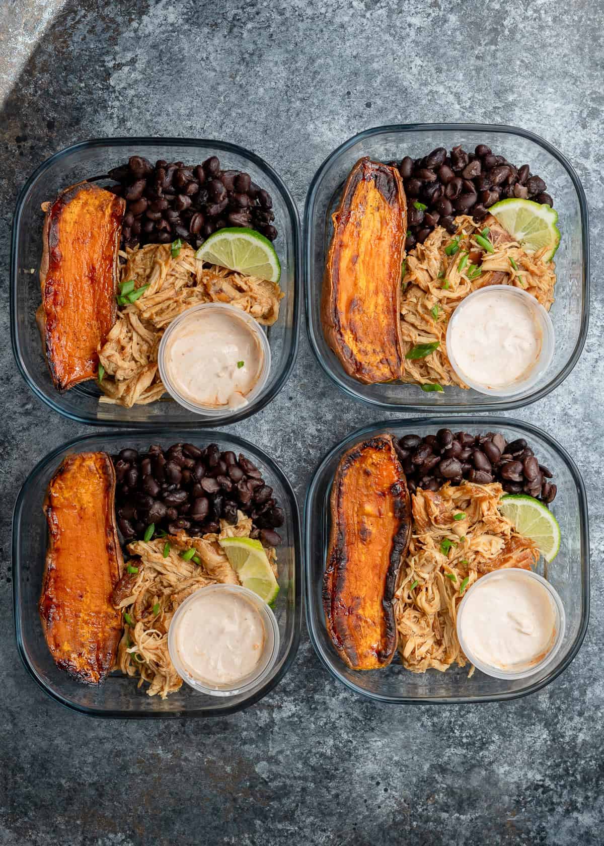 overhead image of 4 honey chipotle chicken bowls in clear meal prep containers