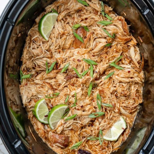 shredded chicken in a slow cooker after being tossed in honey chipotle sauce