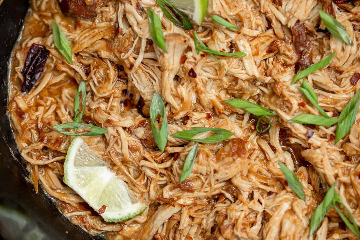 an overhead shot of shredded honey chipotle chicken in a slow cooker