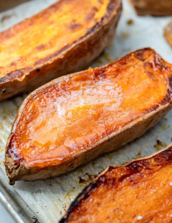overhead image of 3 sliced sweet potatoes on cooking sheet