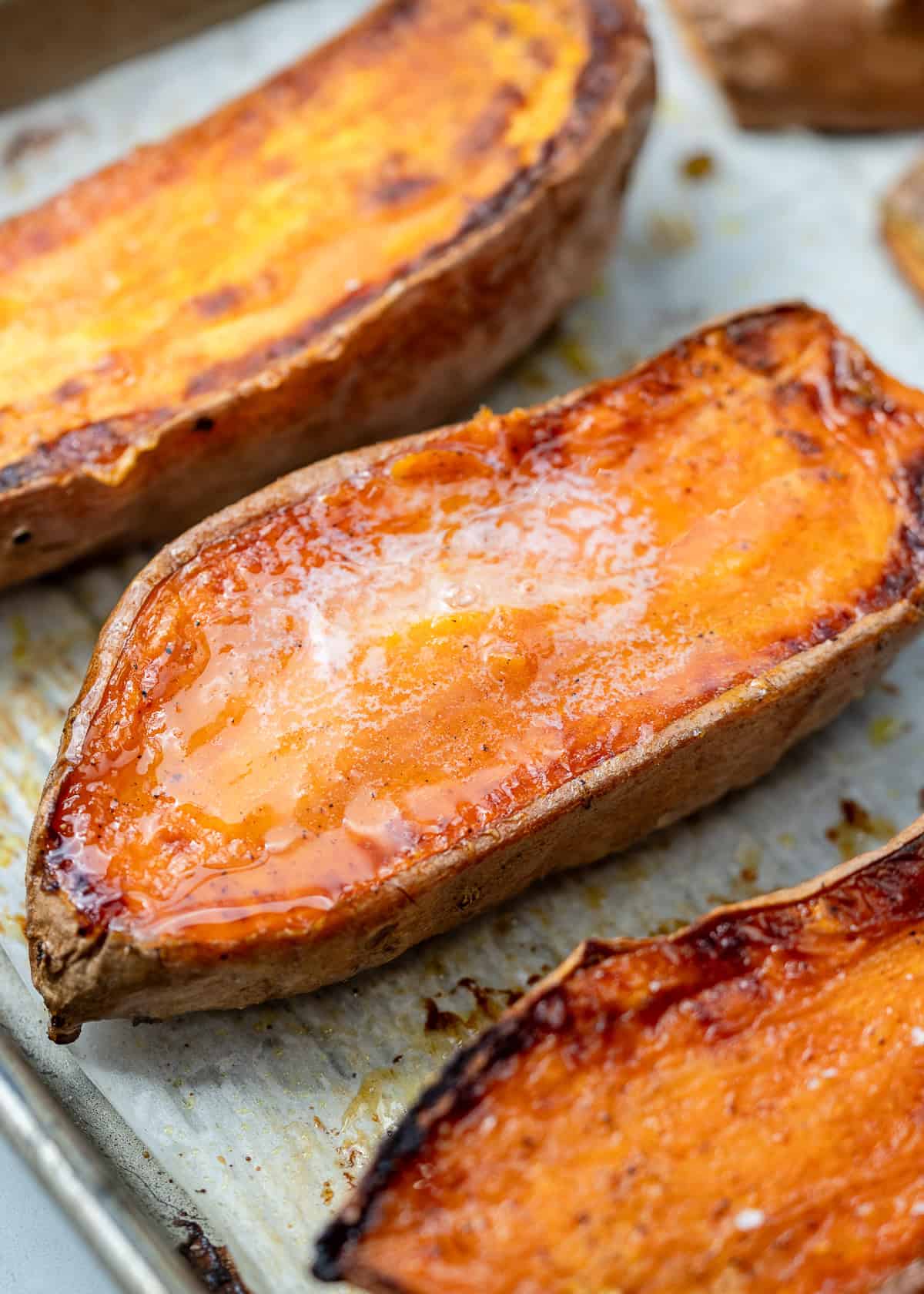 overhead image of 3 sliced sweet potatoes on cooking sheet